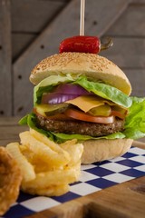 Hamburger and french fries on chopping board