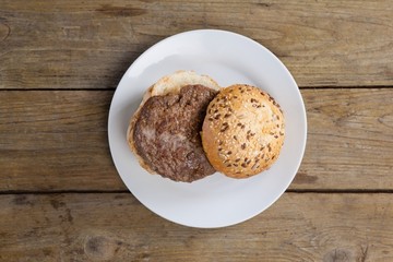 Hamburger in plate on wooden table