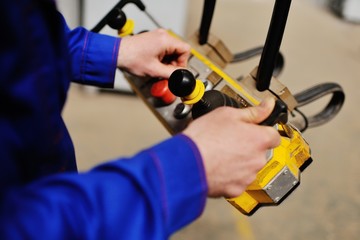 Man, factory, remote control in the hands of a production background