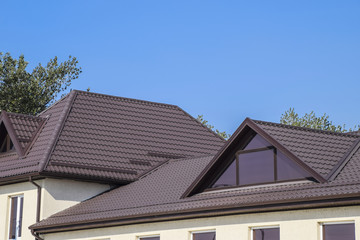 Obraz premium House with plastic windows and a brown roof of corrugated sheet