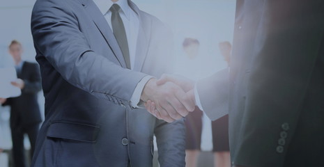 businessmen handshaking after striking deal. on a background sunrise