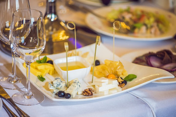Honey and cheeses on a white plate, food