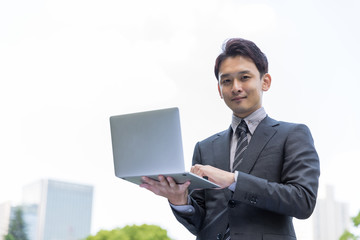 portrait of young asian businessman in park