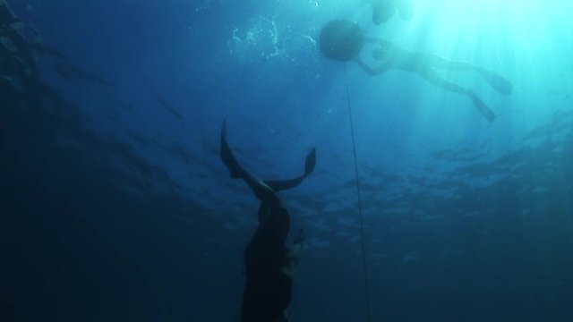 Scuba diver free dives in open ocean, POV