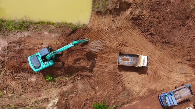 Backhoe and truck working construction site in thailand. Aerial view