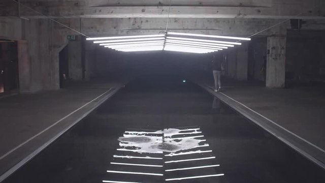 Slow motion shot of white fluorescent lighting turn on and off and reflecting in the water in industrial building. Many lighting neon lights blinking and flashing on the ceiling.