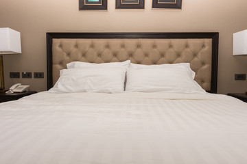 White bedroom with white bed and two pillow in hotel room.