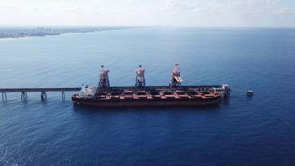 Large bulk carrier ship docking - Unloading coal ship by cranes on the power station dock