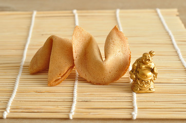 A figurine of a Buddha displayed with fortune cookies