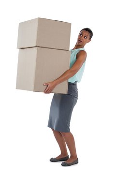 Businesswoman carrying heavy boxes