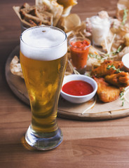Glass of beer on background of the snacks