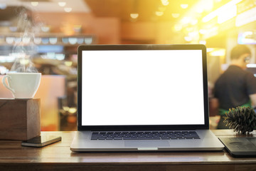 Laptop blank screen on desk in morning sunshine coffee shop