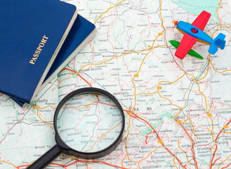Miniature airplane, passport and magnifying glass on map , travel around the world