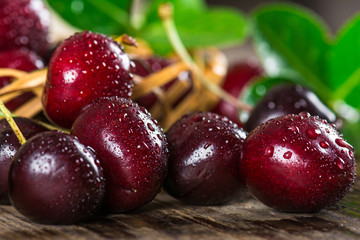 Cherry on a wooden table in a wicker