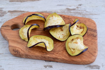 Sliced aubergine on olive wood cutting board