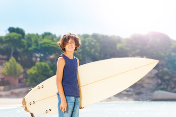 Portrait of cute teenage surfer with surf board