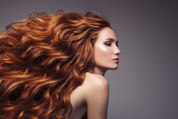 Fototapeta premium Portret kobieta z długim kędzierzawym pięknym imbirowym włosy.