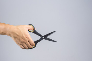 Hand holding office scissors