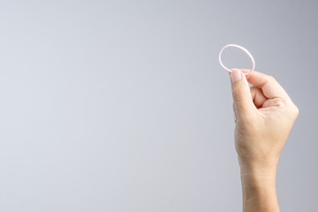 Hand holding pink elastic hair rubber band