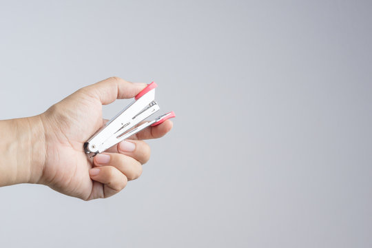 Hand holding stapler, an office supplies for  stapling pages of paper or similar material