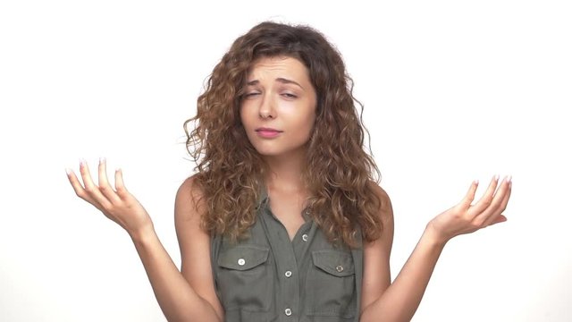 sarcastic young woman throwing up hands to sides doing refusal gesture with index finger closeup isolated over white background slomo. Concept of emotions