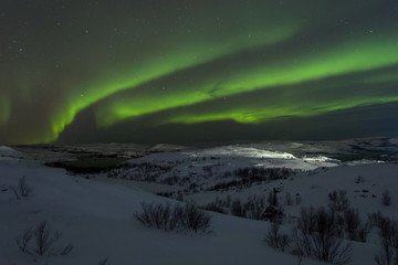 Tundra and hills covered with snow and polar lights.