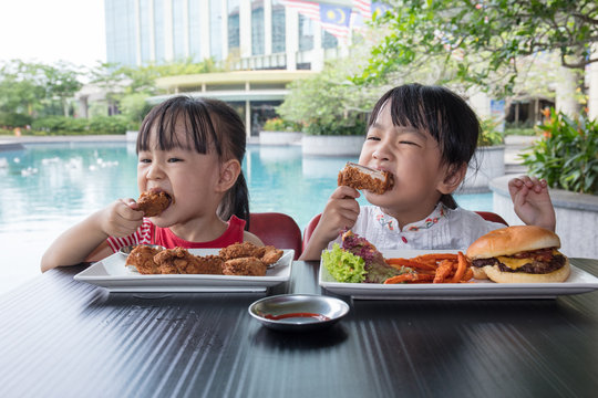 Asian Little Chinese Girls Eating Burger and Fried chicken