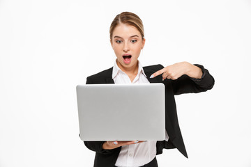 Shocked blonde business woman holding laptop computer