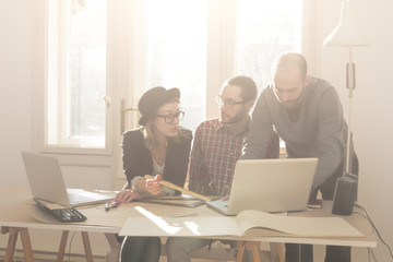 Group of young people / architects being creative in a small office.