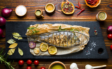 Delicious grilled fish on a wooden background