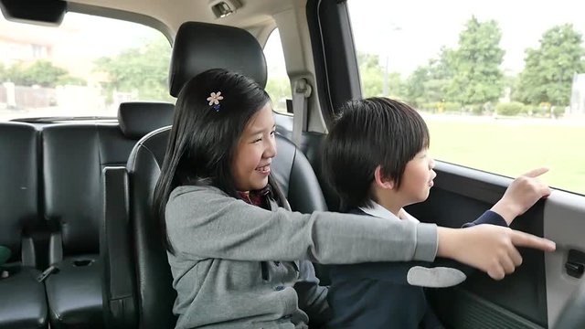 Happy Asian children travels by car, slow motion 