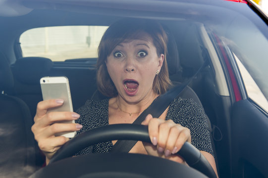 beautiful woman  driving car while texting using mobile phone distracted