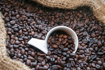 White ceramic mug with coffee beans in sag.