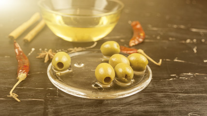 olives olive oil and various condiments on a dark background