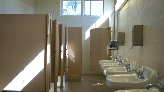 Establishing interior shot of empty public bathroom in the afternoon - ALT