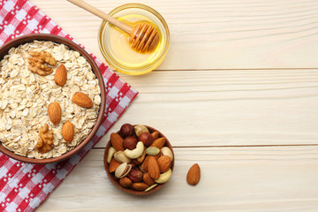 healthy breakfast. oatmeal, honey and nuts on white wooden table. Top view with copy space