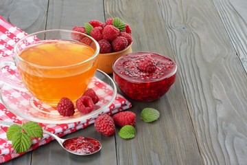 healthy background. raspberry with raspberry jam and tea on dark wooden background. top view with copy space