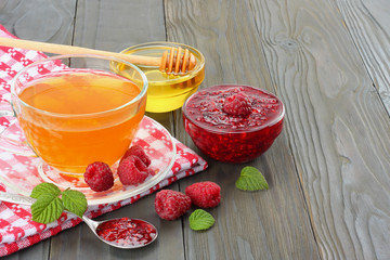 healthy background. raspberry with raspberry jam, honey and tea on dark wooden background. top view with copy space
