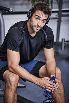 Gym dude with headphones and water, portrait