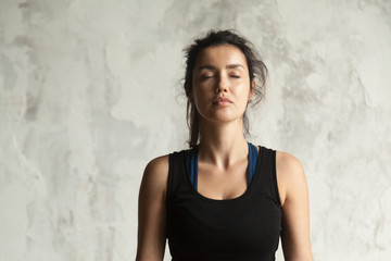 Portrait of young attractive yogi woman with her eyes closed in meditating pose, relaxation...