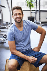 Fototapeta na wymiar Smiling athlete in t-shirt in gym, portrait