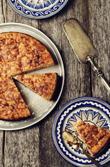 Rice pie cake with dried fruit on a vintage wooden table. Selective focus 