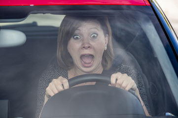 female rookie new driver young beautiful woman scared and stressed while driving car in fear and...