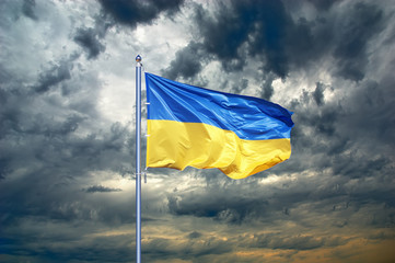 Fototapeta premium Ukraine flag. Ukrainian flag on black storm cloud sky. stormy weather