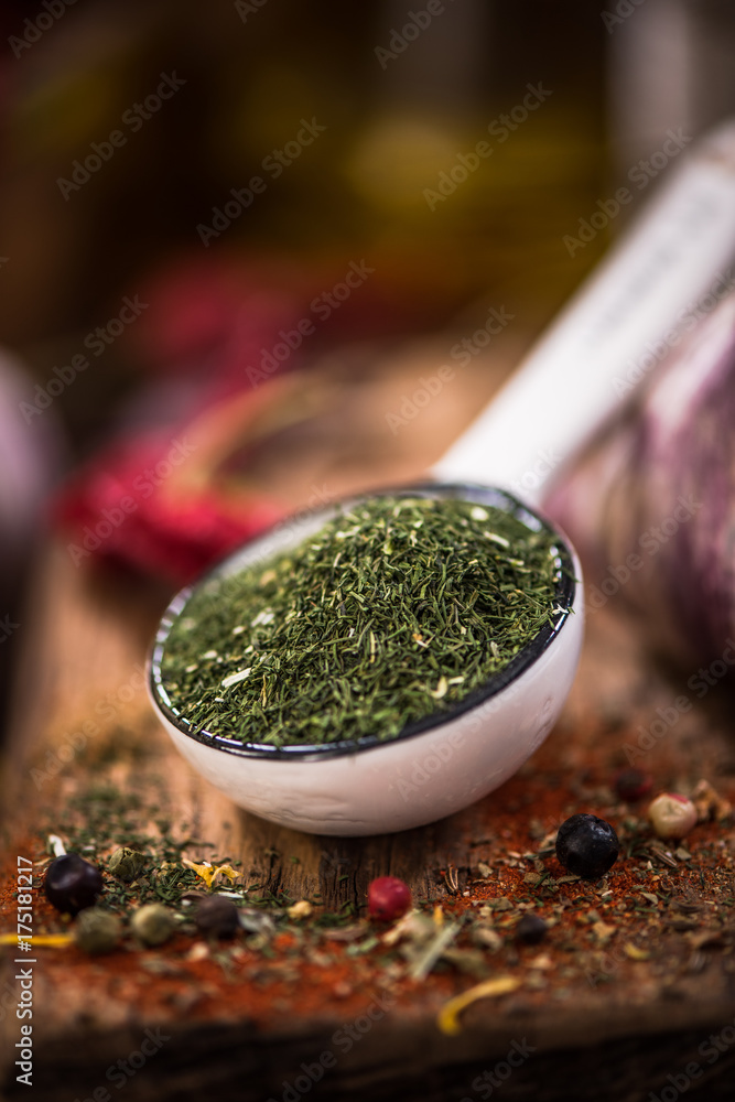 Wall mural Dried dill on spoon. Spices and herbs