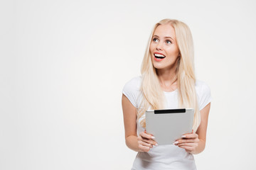Fototapeta premium Portret podekscytowana blondynka gospodarstwa komputer typu tablet