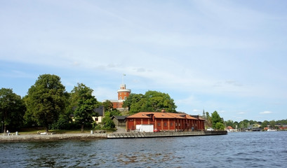 Fototapeta na wymiar Scenic view of the small red castle, brick citadel Kastellet on the island Kastellholmen in central of the city, sunny day, Stockholm, Sweden