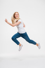 Full length portrait of a happy excited woman jumping