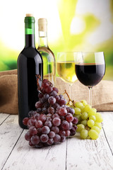White wine and red wine in a glass with fall grapes, white woode