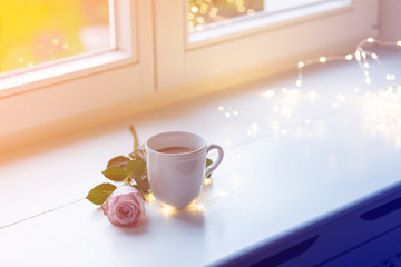 White warm cup of tea of coffee and pink rose
